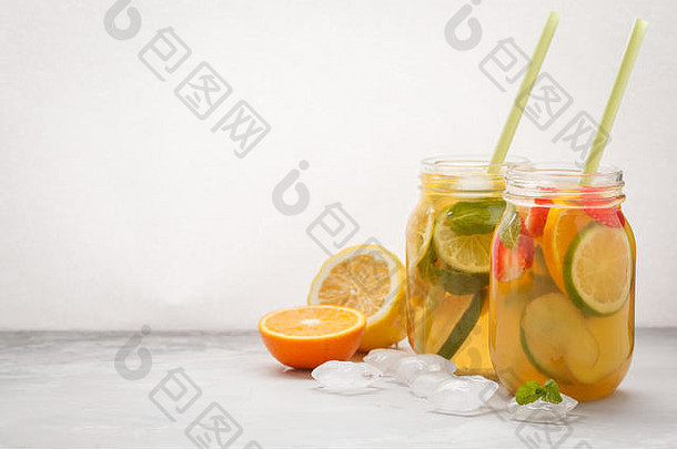 水果冰茶和生姜草本冰茶，在玻璃罐中加入薄荷，白色背景，空间。<strong>夏日清爽</strong>饮料概念。