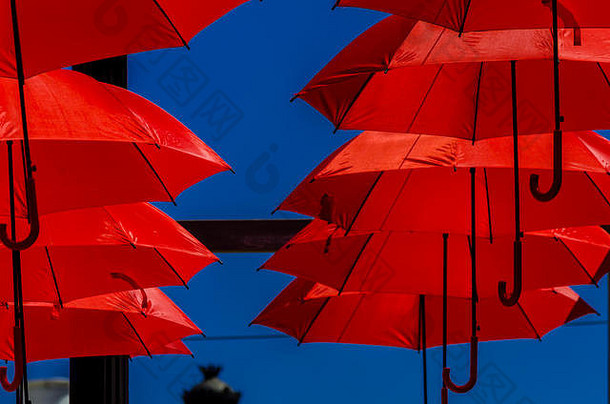 色彩鲜艳的雨伞城市街装饰挂色彩斑斓的雨伞蓝色的天空旅游吸引力阳光明媚的一天