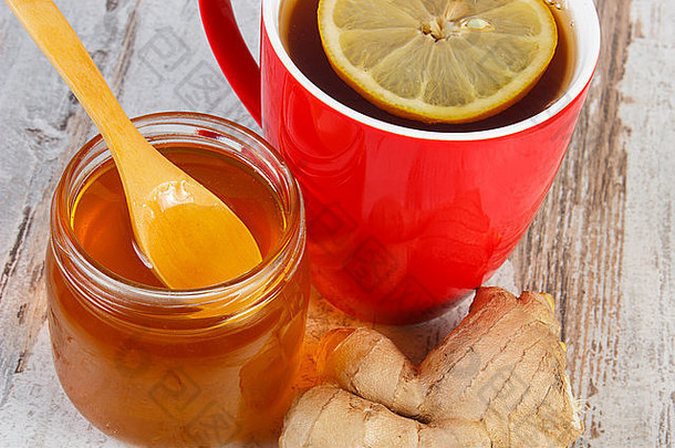 蜂蜜在玻璃罐里，<strong>生姜</strong>和一杯热柠檬茶放在古老的木制白桌子上，健康食品，增强<strong>免</strong>疫力