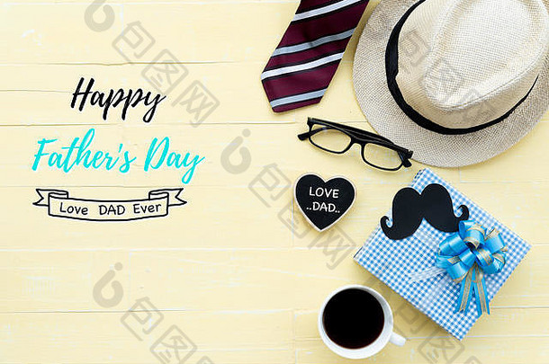 父亲节快乐概念。红领带、眼镜、帽子、小胡子、黑心形标签上印有“爱爸爸”字样的礼品盒，明亮的黄色粉彩木桌