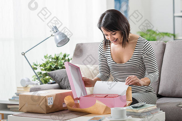 快乐兴奋女人首页收到了邮政包裹unboxing礼物交付在线购物概念