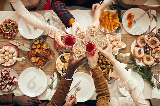 顶视图背景：当与朋友和家人一起庆祝圣诞节时，人们在节日餐桌上举杯，空间