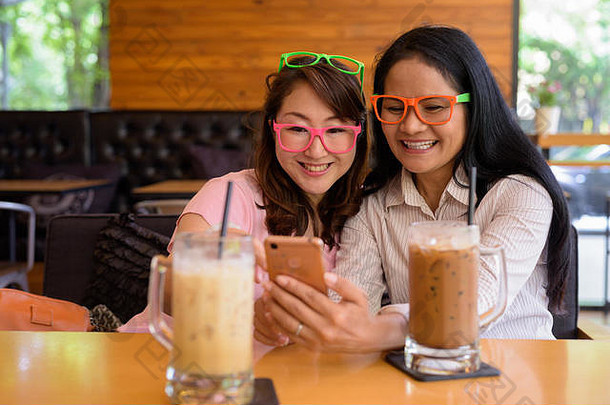 两个成熟的亚洲女人一起在咖啡馆闲逛