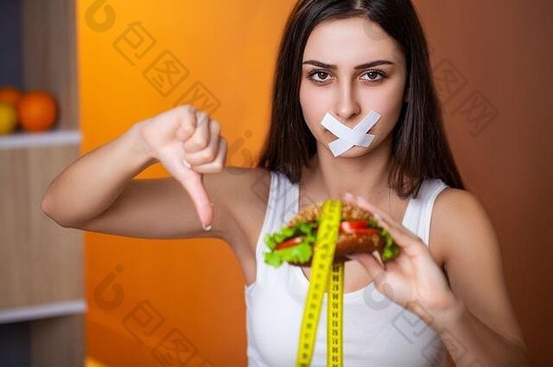 肖像女人想要吃汉堡，但卡在了skochem嘴上，这是饮食的概念