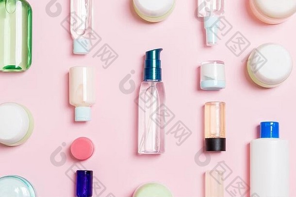 一组塑料贴身瓶平放组合，以粉色化妆品为背景，空白处为您设计。一套白色化妆品盒