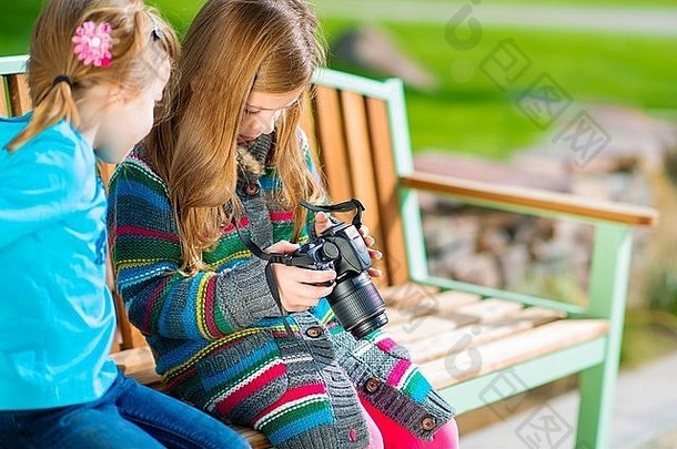 <strong>孩子们</strong>一边玩新的数码相机一边学习<strong>摄影</strong>。两个带照相机的女孩。