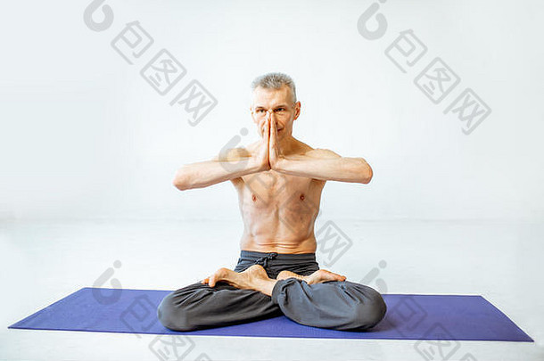 老人在白色工作室练习瑜伽
