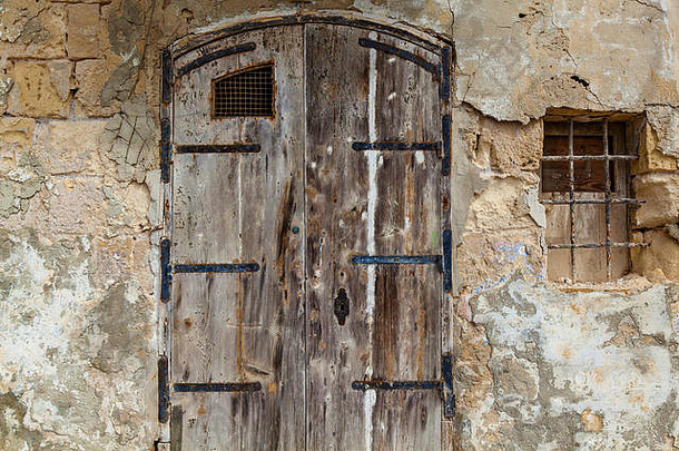 马耳他岛上一扇古老木门的纹理，带有不同寻常的金属把手