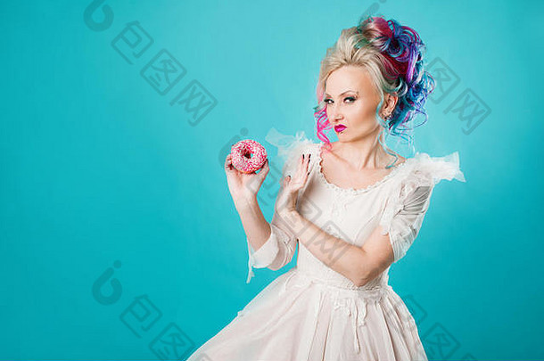 有趣的年轻的女人彩色的头发给糖果饮食快碳水化合物蓝色的背景
