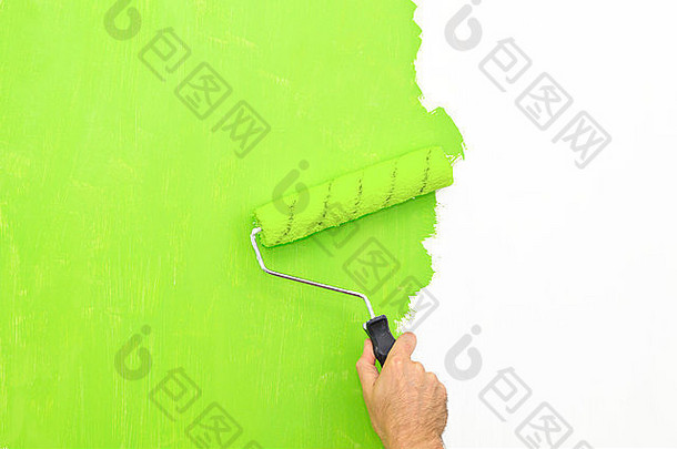 用涂有绿色油漆的滚筒粉刷墙壁