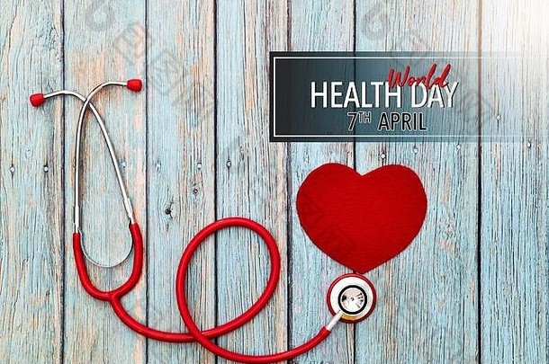 世界卫生日，医疗保健和医疗概念，蓝色木质背景上的红色听诊器和红色心脏