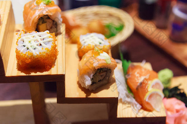 日本鲜鱼食品菜单，三文鱼寿司和生鱼片，装饰在传统日本餐厅的木制台阶上。健康食品