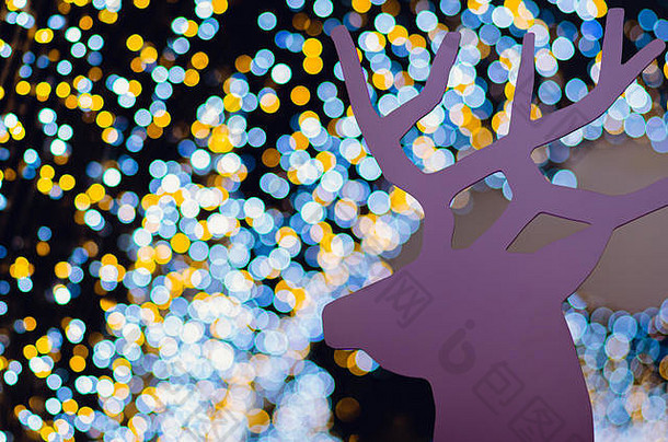 粉色木制驯鹿用五颜六色的波基灯装饰圣诞假期。