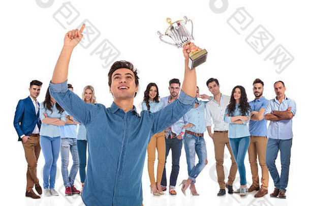 成功的休闲团队，年轻领袖举着<strong>奖杯</strong>和一只手在空中庆祝