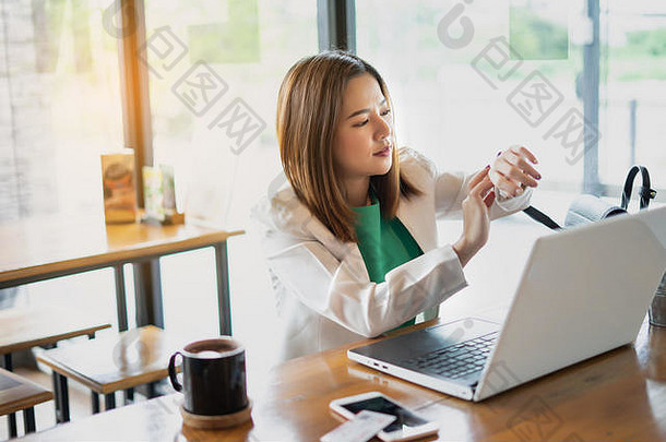 女商人在咖啡馆使用电脑和智能手机。商务放松和休息时间。自由职业者和自由职业者。商业