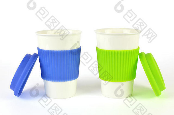 两个装咖啡或热饮料的白色容器，旁边有蓝色和绿色的隔热套和盖子，隔离在白色表面