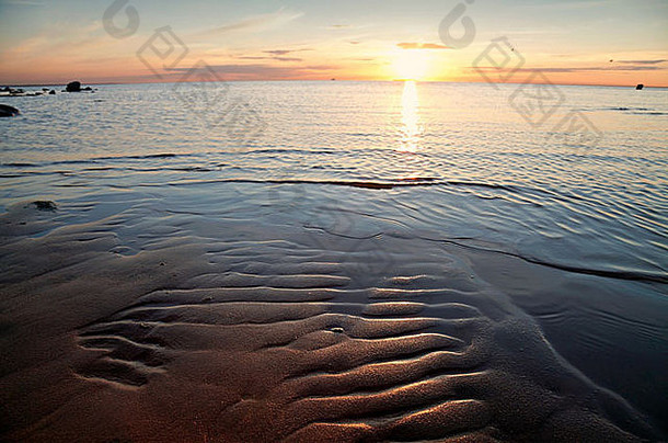 海上金色的<strong>日</strong>落。夕阳反射在水面和沙滩上的海岸景观