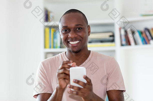 非洲裔美国人秃头成熟男子在家里室内发短信