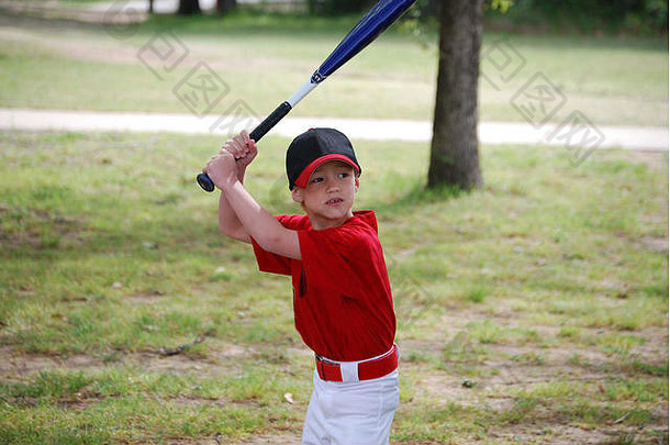 穿着球衣拿着球棒的小棒球运动员的肖像。