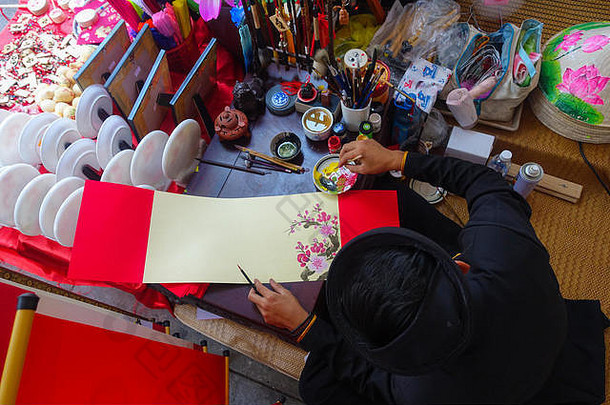 书生在新年写书法。这位书法家在春天的集市上用书法作画。越南文化