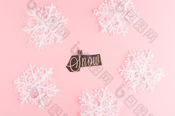 粉红色背景上的雪花，上面刻有雪花文字。寒假节日贺卡。<strong>圣诞</strong>节平面布置概念。