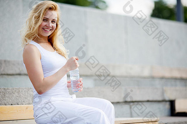 高加索人微笑女人白色衣服瓶水