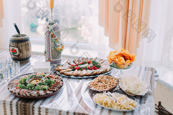 一桌不同的美味小吃，以传统的东斯拉夫鲁拉尔风格提供，背景上有明亮的窗户