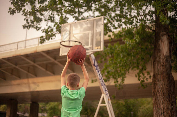 男孩玩篮球持有球手拍摄篮板上身体后视图拍摄