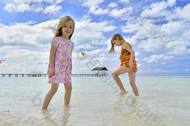 阳光明媚的日子里，可爱的小女孩在沙滩上嬉戏。古巴。可可豆。