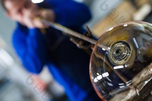 贝洛斯拉夫/保加利亚-2019年5月5日：吹制玻璃机形成美丽的玻璃片。一个玻璃工匠正在烧制和吹制一件艺术品。