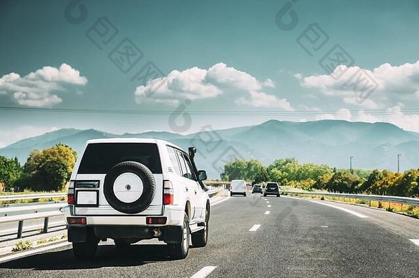 SUV汽车在高速公路上行驶，背景为山区景观。汽车旅行概念。