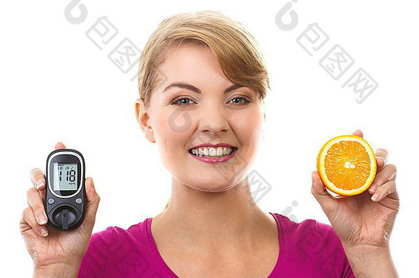 幸福的女人拿着血糖仪，血糖水平和新鲜成熟的橙子，糖尿病的概念，