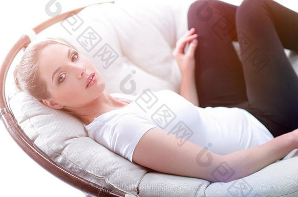 疲惫的女人在藤条制成的安乐椅上休息