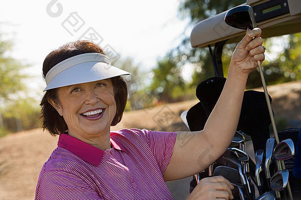 女人选择高尔夫球俱乐部高尔夫球车微笑肖像