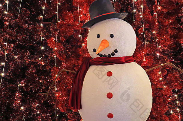 大雪人前面闪闪发光的人工红色的松树圣诞节室内装饰