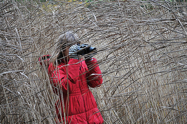 一个12岁的女孩用双筒望远镜寻找鸟类