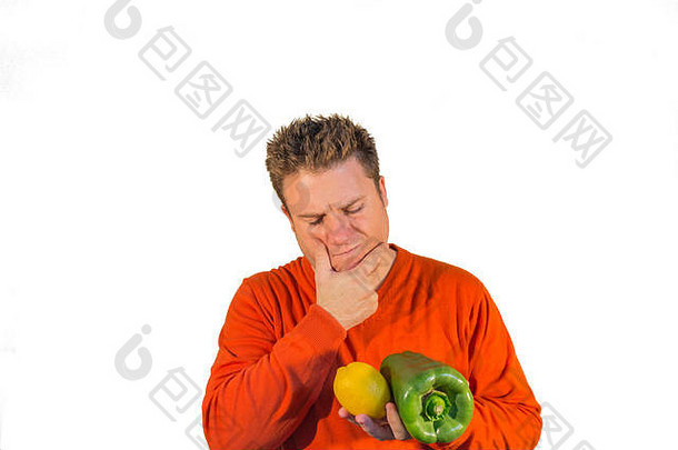 持怀疑态度的家伙拿着水果和蔬菜，特别是胡椒和柠檬