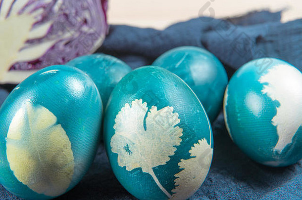 木制桌子上摆放着有机蓝色复活节彩蛋、复活节节日装饰、复活节概念背景和空间
