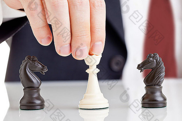 在两个争吵的骑士之间拿着象棋皇后的商人-冲突管理概念