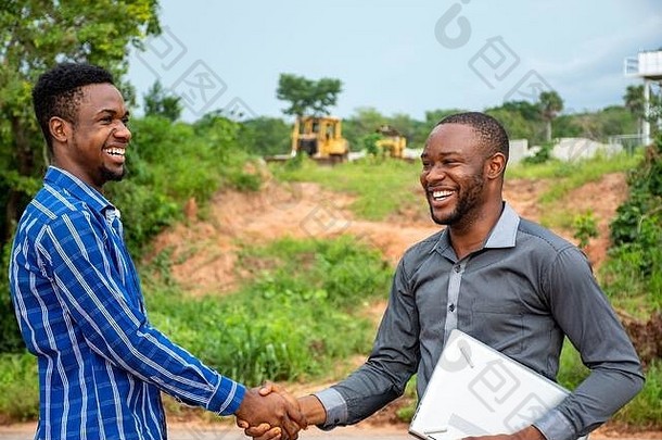 年轻的非洲现代农民握手，对交易感到满意
