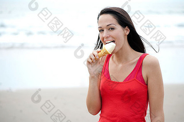 在海滩上舔冰淇淋的女人