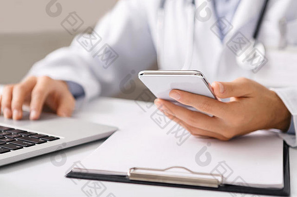医生在工作场所使用智能手机和笔记本电脑。