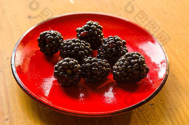 陶瓷盘上的大型多汁新鲜黑莓浆果，特写