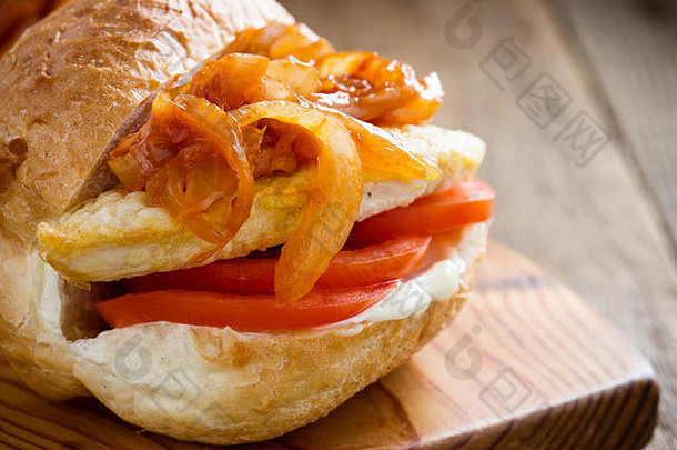 乡村木桌上的三明治，配炸鸡胸肉和甜洋葱酱