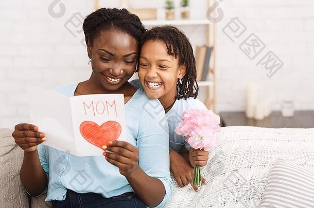 黑人女孩用鲜花和贺卡向母亲祝贺