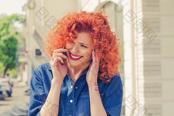 听到肖像愤怒的沮丧红色的卷曲的头发女人会说话的移动<strong>电话</strong>站城市背景负表情