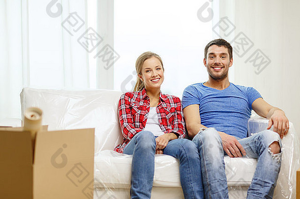 微笑的夫妇在新家的沙发上放松