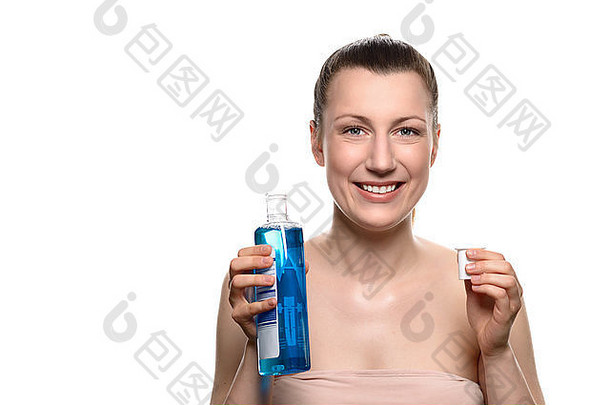 近距离微笑的年轻女子戴着一瓶漱口水，看着镜头，隔离在白色背景上。
