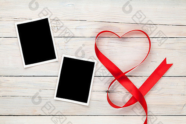 情人节心形红丝带和木制桌子背景上的空白相框
