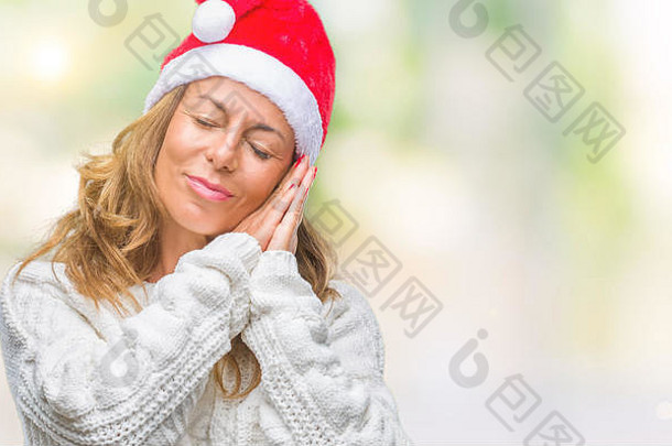 中年西班牙裔老年妇女，戴着圣诞帽，在与世隔绝的背景下睡着，疲惫不堪地做着梦，双手合十，面带微笑